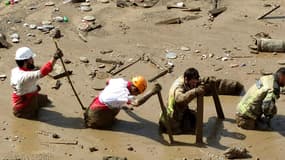 Des membres d'une équipe de secours travaillant sur le site d'une crue soudaine dans le quartier d'Emamzadeh Davoud, au nord-ouest de Téhéran, le 28 juillet 2022.