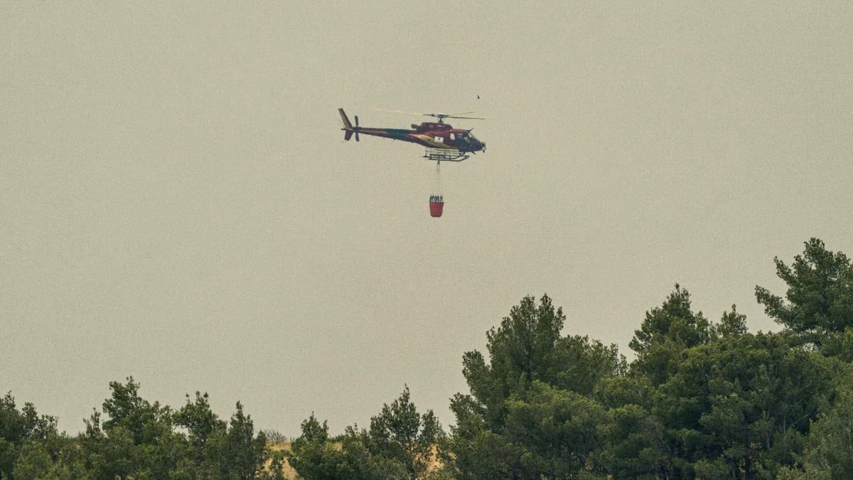 Cette photographie montre un hélicoptère bombardier d'eau se préparant à larguer de l'eau sur un point chaud dans une forêt en feu lors d'un incendie près de Moux (Aude), le 5 juillet 2025. (Photo d'illustration) Cette photographie montre un hélicoptère bombardier d'eau se préparant à larguer de l'eau sur un point chaud dans une forêt en feu lors d'un incendie près de Moux (Aude), le 5 juillet 2025. (Photo d'illustration)
