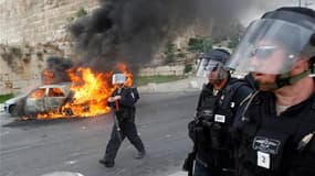 Véhicule en flamme près de la Vieille ville de Jérusalem, mercredi. Des policiers israéliens ont pénétré mercredi dans le complexe de la mosquée al Aksa, dans la Ville Sainte, pour disperser des Palestiniens qui lançaient des pierres en direction du mur d