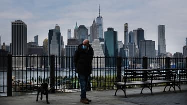 Un homme portant un masque et promenant son chien à New York le 23 avril 2020