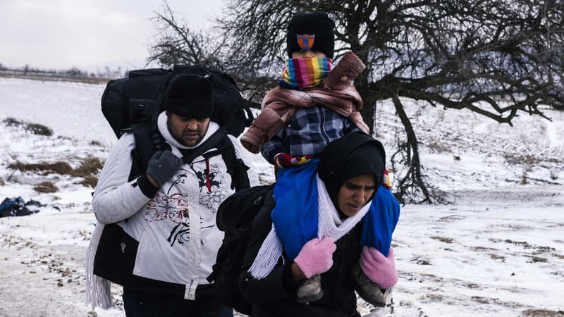 Une famille de réfugiés marche dans un champs enneigés après avoir traversé la frontière entre la Macédoine et la Serbie.