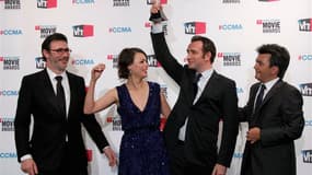 Jean Dujardin porte le trophée du meilleur film décerné jeudi soir lors des Critics' Choice Awards au film muet "The Artist" de Michel Hazanavicius (à gauche), aux côtés de sa partenaire dans le film Bérénice Bejo et du producteur Thomas Langmann (à droit