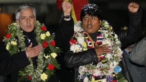 Le Président bolivien Evo Morales (à droite) acclamé à son arrivée à La Paz, chante l'hymne national avec le vice-président Alvaro Garcia Linera. L'escale forcée de l'avion transportant le président bolivien à Vienne a provoqué une crise diplomatique entr