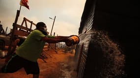 Un chilien tente d'éteindre l'incendie en cours, janvier 2024 