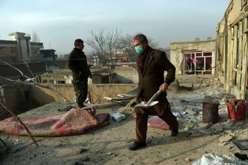 Des Afghans déblaient après l'attentat contre un restaurant français le 2 janvier 2016 à Kaboul