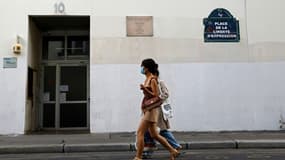 Deux personnes passent devant l'immeuble où des journalistes de Charlie Hebdo ont été assassinés en janvier 2015 par des djihadistes à Paris, le 30 août 2020