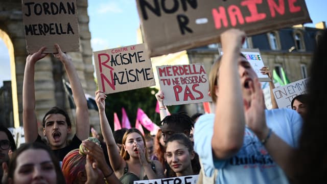 Des manifestants brandissent des pancartes et chantent contre le parti politique d'extrême droite français Rassemblement National (RN) après son succès aux élections européennes, sur la place de la Victoire à Bordeaux, dans le sud-ouest de la France, le 10 juin 2024.