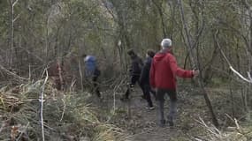 Des adolescents de Coaraze (Alpes-Maritimes) accompagnés de bénévoles empruntant un chemin escarpé pour se rendre au collège de Contes après l'éboulement de la RN15 bloquant la route d'accès, le mardi 19 mars 2024.