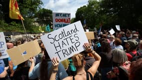 Des manifestants brandissent des pancartes lors d'une manifestation de la « Stop Trump Coalition » près du consulat américain à Édimbourg, en Écosse, le 26 juillet 2025.