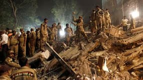 Secouristes à la recherche d'éventuels survivants dans les décombres après l'effondrement d'un immeuble tard lundi soir à New Delhi. Le sinistre a fait au moins 55 morts et 75 blessés, selon les médias indiens. /Photo prise le 16 novembre 2010/REUTERS/Adn