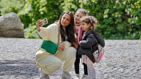 Une femme prenant une photo avec ses enfants (illustration)