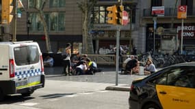 Des blessés sont traités sur place à Barcelone, le 17 août 2017, après l'attentat