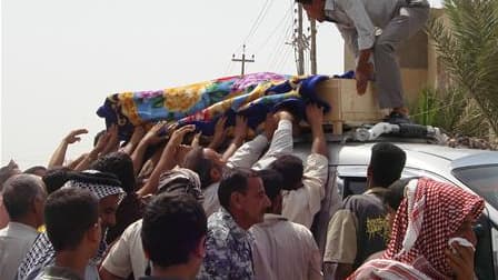 Lors des funérailles d'une victime d'un attentat à Al Souaïra, à 50 km au sud-est de Bagdad. Plusieurs attentats ont fait 65 morts et 200 blessés lundi en Irak, surtout dans la région de Bagdad. /Photo prise le 10 mai 2010/REUTERS/Habib