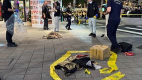 L'agence de presse centrale de Taïwan (CNA) le 19 décembre 2025 montre les équipes médico-légales de la police installant un cordon de sécurité à l'extérieur de la librairie Eslite Nanxi à proximité, à Taipei.