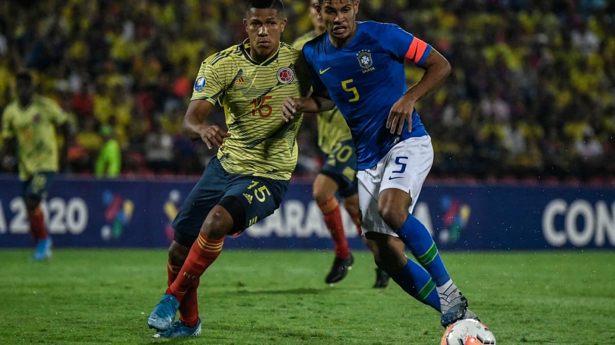 Le Brésilien Bruno Guimaraes (en bleu) au duel avec le Colombien Jaime Alvarado lors du tournoi pré-olympique pour Tokyo en février 2020 Le Brésilien Bruno Guimaraes (en bleu) au duel avec le Colombien Jaime Alvarado lors du tournoi pré-olympique pour Tokyo en février 2020