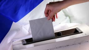 n électeur glisse un bulletin de vote dans l'urne (illustration)