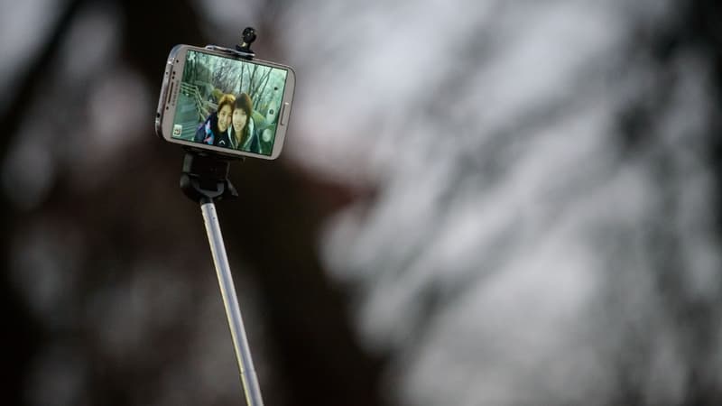 Deux personnes prennent un selfie avec un "selfiestick" (illustration)