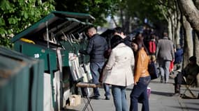 Des personnes devant des étals de bouquinistes à Paris le 12 mai 2013