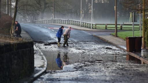 Des habitants essaie de déblayer la route après une inondation, le 27 décembre 2015 à Summerseat, dans le nord de l'Angleterre