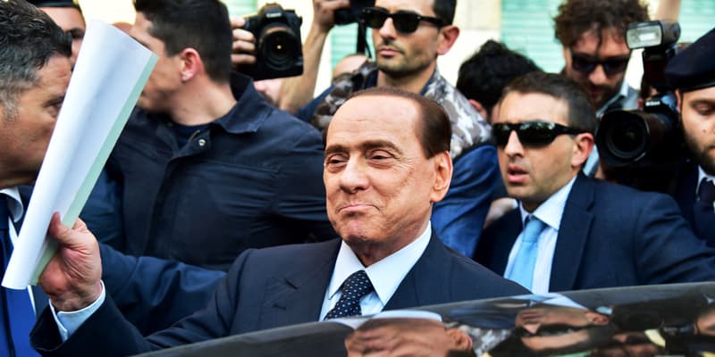 L'ancien chef du gouvernement italien Silvio Berlusconi quitte un bureau de justice de Milan, le 23 avril 2014, entouré de ses gardes de sécurité.