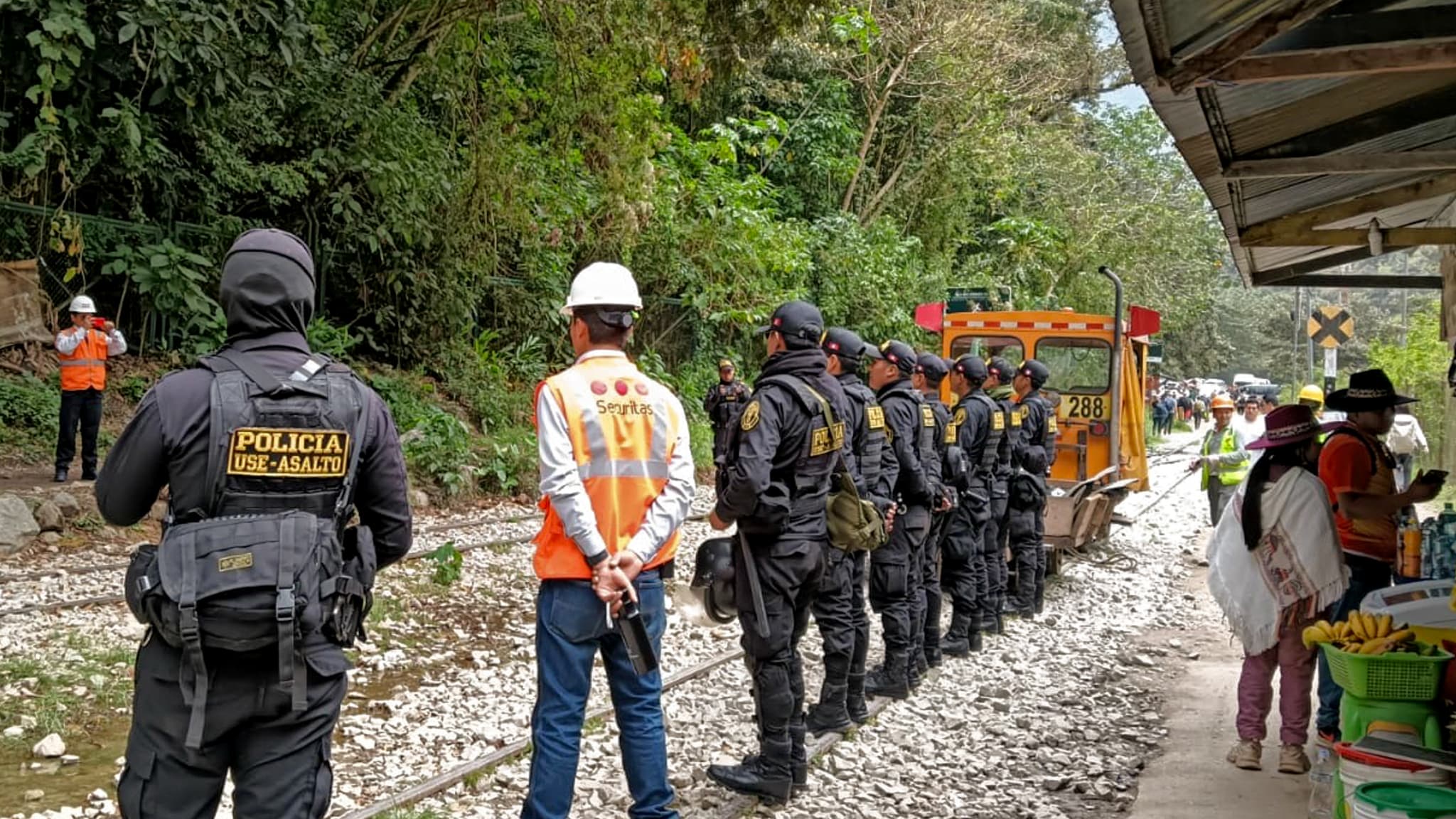 Des policiers en faction posent pour une photo sur la voie ferrée près du Machu Picchu Pueblo, département de Cuzco, Pérou, le 16 septembre 2025