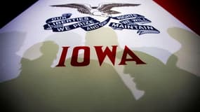 L'ombre des électeurs sur un drapeau de l'Etat de l'Iowa, où les républicains lancent ce mardi soir le long processus de désignation du futur adversaire de Barack Obama à l'élection présidentielle américaine de novembre prochain. /Photo prise le 2 janvier