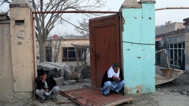 Des Afghans devant leur maison détruite à Kaboul, le 2 janvier 2016 conséquence de l'attentat contre le restaurant français