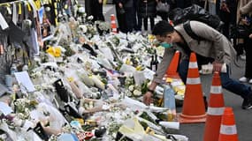 Un homme dépose des fleurs blanches en mémoire des victimes de la bousculade mortelle lors d'une célébration d'Halloween à Séoul, le 3 novembre 2022