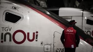 Un employé de la SNCF se tient près d'un TGV inoui sur un quai de la gare Montparnasse à Paris, le 6 mai 2025, deux jours avant la grève des transports ferroviaires prévue pour le week-end férié du 8 mai. 