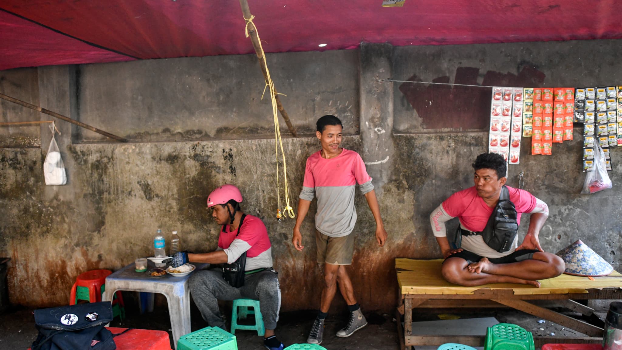 Des livreurs s'assoient et se reposent dans un restaurant de rue pendant la canicule à Yangon, le 29 avril 2024.