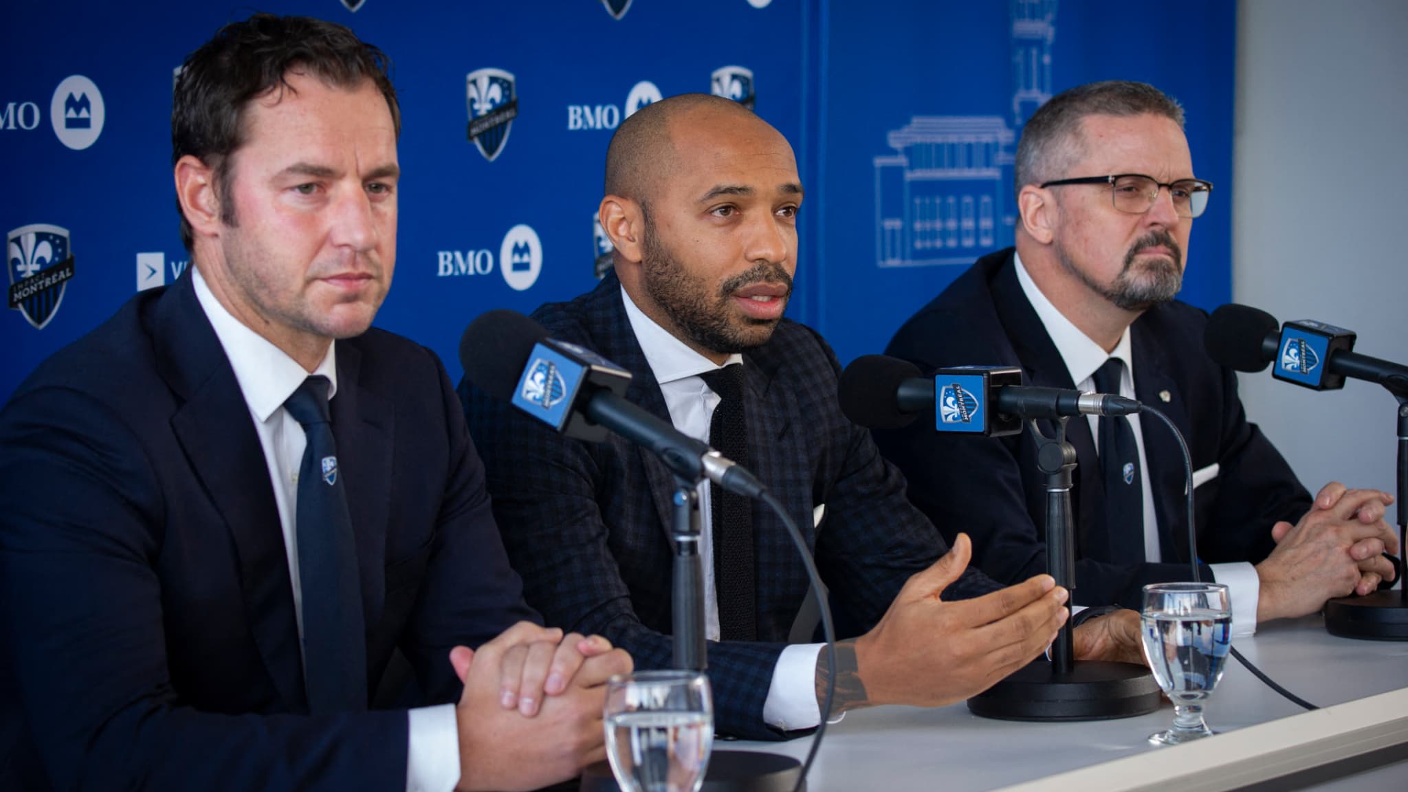Le directeur sportif Olivier Renard (à gauche) et le président Kevin Gilmore entourent Thierry Henry lors de sa conférence de présentation à l'Impact Montréal en novembre 2019