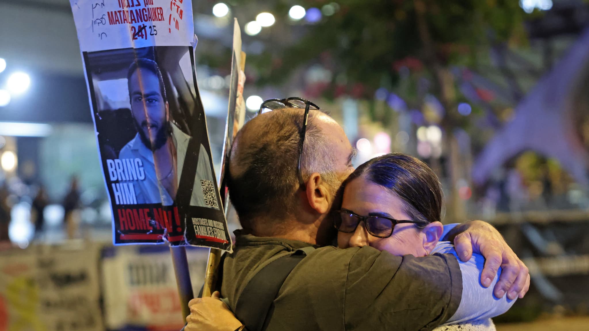 Des manifestants s'embrassent, devant le ministère israélien de la Défense à Tel Aviv le 15 janvier 2025.