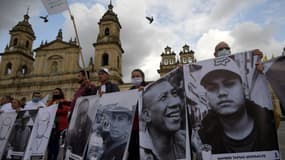 D’anciens guérilleros des FARC et signataires de l’accord de paix avec le gouvernement brandissent les portraits de leurs compagnons assassinés, lors d'une manifestation à Bogota le 7 mars 2022. 