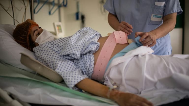 Une infirmière au chevet d'une femme enceinte à la maternité des Diaconesses à Paris, le 17 novembre 2020