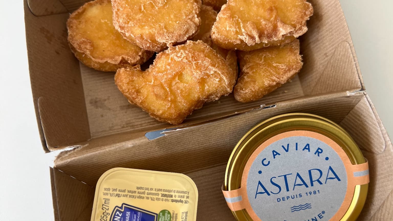 Une boîte de 7 nuggets avec du caviar et une sauce mayonnaise