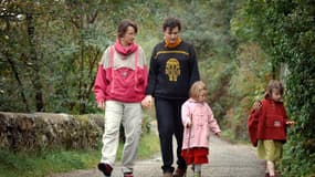 Une famille homoparentale se balade dans un parc - image d'illustration.