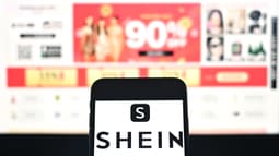 Le logo de la plateforme de fast-fashion Shein affiché sur un smartphone, avec la page du site Web de l'entreprise en arrière-plan, le 6 décembre 2024 à Bangkok, en Thaïlande (photo d'illustration).