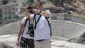 Des touristes prenant un selfie à Amman, en Jordanie, devant un amphithéâtre romain.