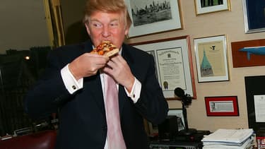Donald Trump goûte une pizza, en avril 2005, dans les bureaux de sa Trump Tower, à New York.