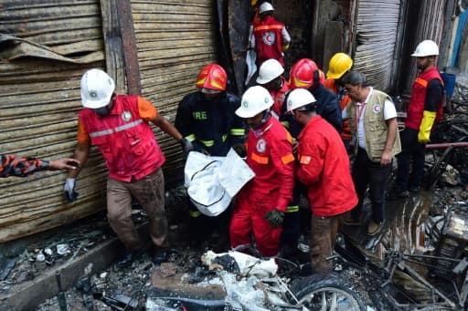 Les pompiers transportent le corps d'une des victimes de l'incendie de Dacca, le 21 février 2019 Les pompiers transportent le corps d'une des victimes de l'incendie de Dacca, le 21 février 2019