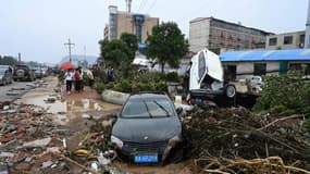 La population constate les dégâts après les intempéries à Mihe, dans la province de Henan (centre de la Chine), le 22 juillet 2021.