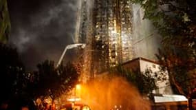 Evacuation d'un blessé après l'incendie qui s'est propagé lundi dans un immeuble résidentiel de 28 étages à Shanghai. Le bilan du sinistre s'est alourdi à 53 morts et plus de soixante-dix personnes blessées ou intoxiquées ont dû être hospitalisées, selon
