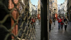 Des piétons dans une rue où les commerces non essentiels ont fermé, le 20 mars 2021 à Paris