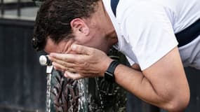 Un homme s'asperge d'eau à Paris, le 13 juillet 2020.