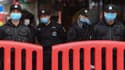 Des policiers et agents de sécurité avec des masques de protection respiratoire, à Wuhan (Chine) le 24 janvier 2020