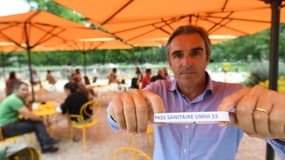 Le président de l'UMIH-33, Laurent Tournier montre un bracelet pass sanitaire au restaurant L'Orangerie, le 18 août 2021 à Bordeaux