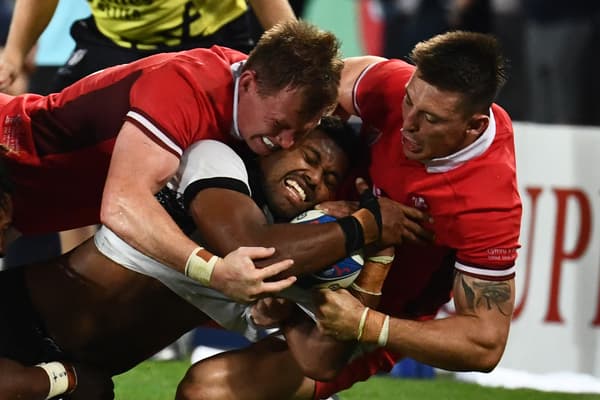 Le Fidjien Ilaisa Droasese plaqué par deux Gallois lors d'un match de Coupe du monde de rugby