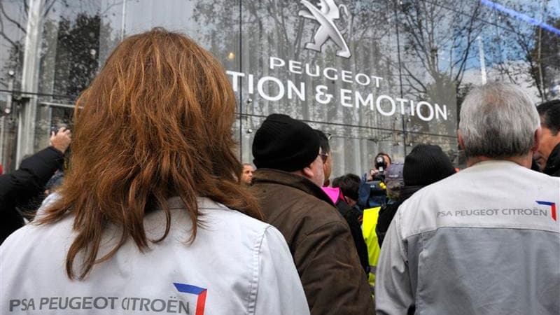 Salariés de PSA Peugeot Citroën devant le siège social du groupe, mardi à Paris. Le ministre du Travail et de l'Emploi, Xavier Bertrand, veut rencontrer prochainement le président du directoire de PSA Peugeot Citroën, Philippe Varin, pour lui demander des