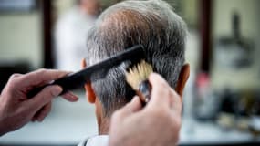 Un coiffeur peigne les cheveux d'un client, à Lisbonne le 16 juillet 2013. (photo d'illustration)