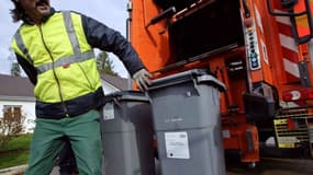 Un éboueur travaillant avec un camion-poubelle. 